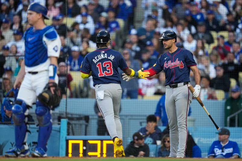 Atlanta Braves' Ronald Acuña Jr. (13) is greeted by Matt Olson, right, after scoring off of a single hit by Austin Riley during the fourth inning of a baseball game against the Los Angeles Dodgers in Los Angeles, Saturday, May 4, 2024. (AP Photo/Ashley Landis)