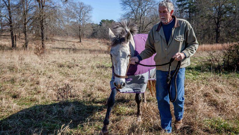 Frans Insinger of Rockdale County, shown here with Raine at the horse farm where he and his wife board horses, stays relatively healthy. But health insurance premiums on the Affordable Care Act’s exchange for Insinger and his wife have skyrocketed anyway. They make too much to qualify for subsidies, and this year they found that if they lived in the same ZIP code but over the county line, their premium would be $200 less. (PHOTO by BRANDEN CAMP/ special to the AJC)