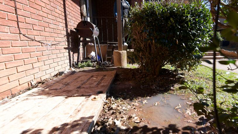 A puddle of raw sewage (bottom right of picture) stands in front of Lolita Evans’ apartment at the Forest Cove apartment complex Tuesday, Feb. 1, 2022. (Daniel Varnado/For the Atlanta Journal-Constitution)