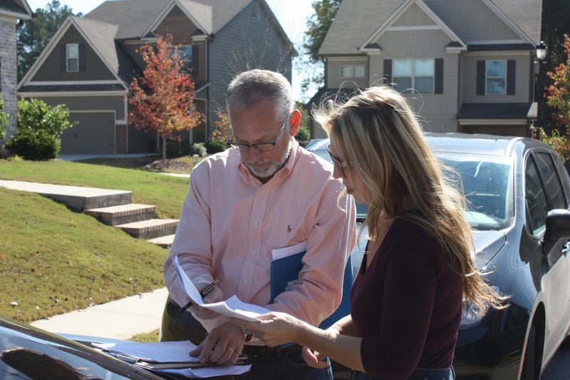 Former Hoschton City Councilman Scott Butler and resident Kelly Winebarger go over a list of registered voters as they collect signatures on a petition to recall Mayor Theresa Kenerly and Mayor Pro Temp Jim Cleveland Nov. 2, 2019. CHRIS JOYNER / CJOYNER@AJC.COM