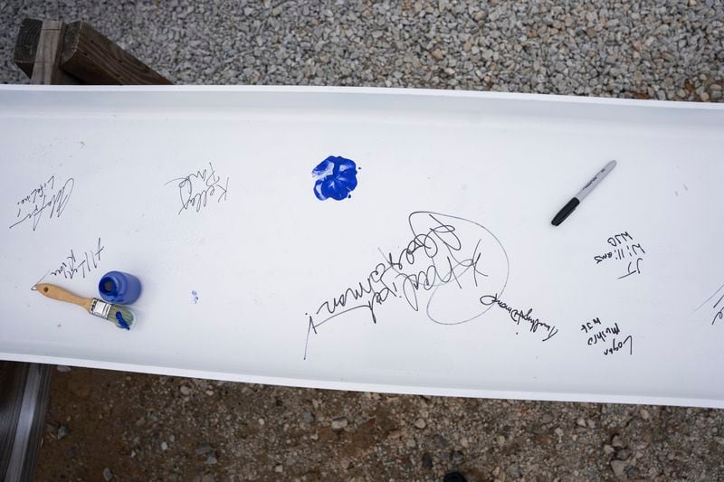 Names are signed and paws printed on the inaugural beam that will be built into the new animal shelter which is set to open this fall in Fulton County, on Friday, May 19, 2023.  (Olivia Bowdoin for the Atlanta Journal Constitution).
