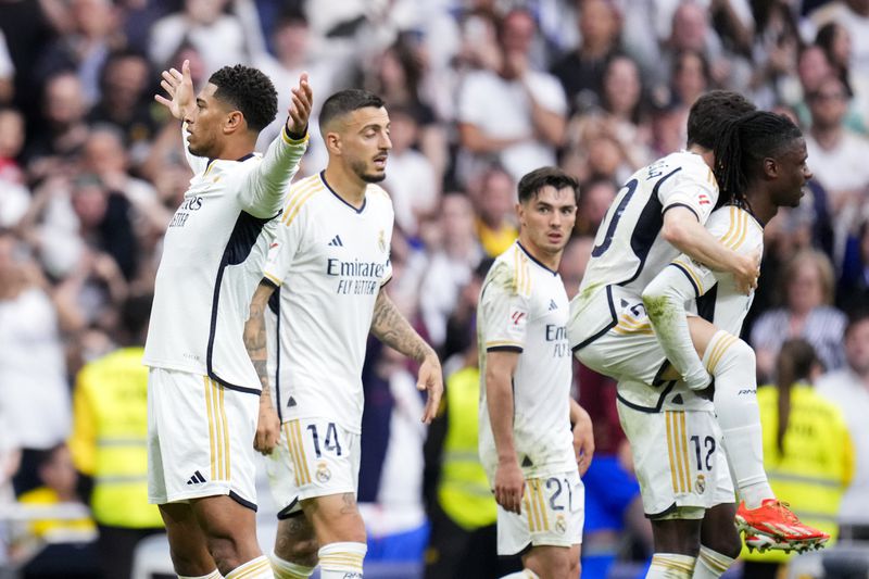 Real Madrid's Jude Bellingham, left, celebrates after scoring his side's second goal during the the Spanish La Liga soccer match between Real Madrid and Cadiz at the Santiago Bernabeu stadium in Madrid, Spain, Saturday, May 4, 2024. (AP Photo/Manu Fernandez)