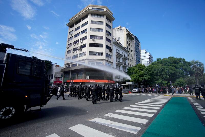 Police use water to disperse an anti-government protest against food scarcity at soup kitchens and against economic reforms proposed by President Javier Milei in Buenos Aires, Argentina, Wednesday, April 10, 2024. (AP Photo/Natacha Pisarenko)