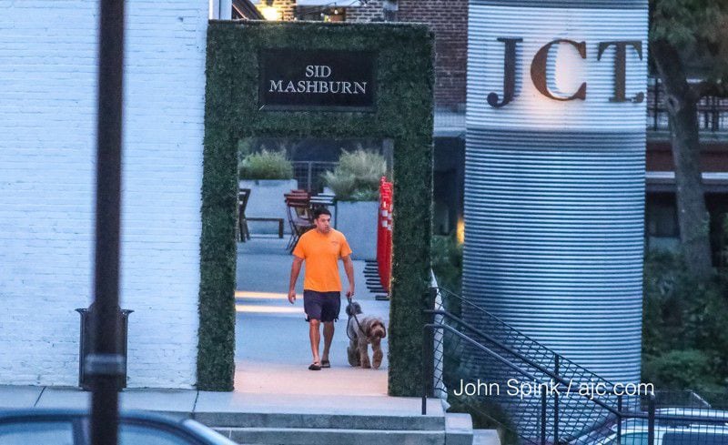A man walked outside JCT Kitchen & Bar the day after a suspected robber allegedly shot a man in the parking lot, chased him inside the popular West Midtown restaurant and continued firing. JOHN SPINK / JSPINK@AJC.COM