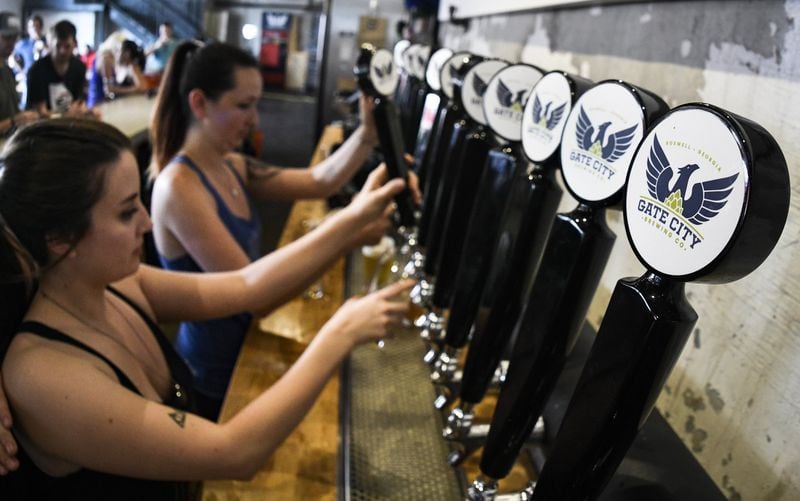 Bartenders work the taps at Gate City Brewing in Roswell earlier this month. Its taproom offers as many as 20 beers on draft seven days a week. CONTRIBUTED BY JOHN AMIS