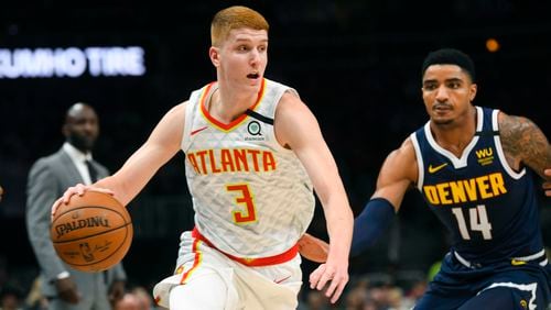 Hawks guard Kevin Huerter (3) drives against Nuggets guard Gary Harris during the first half of Monday's game at State Farm Arena. (AP Photo/John Amis)