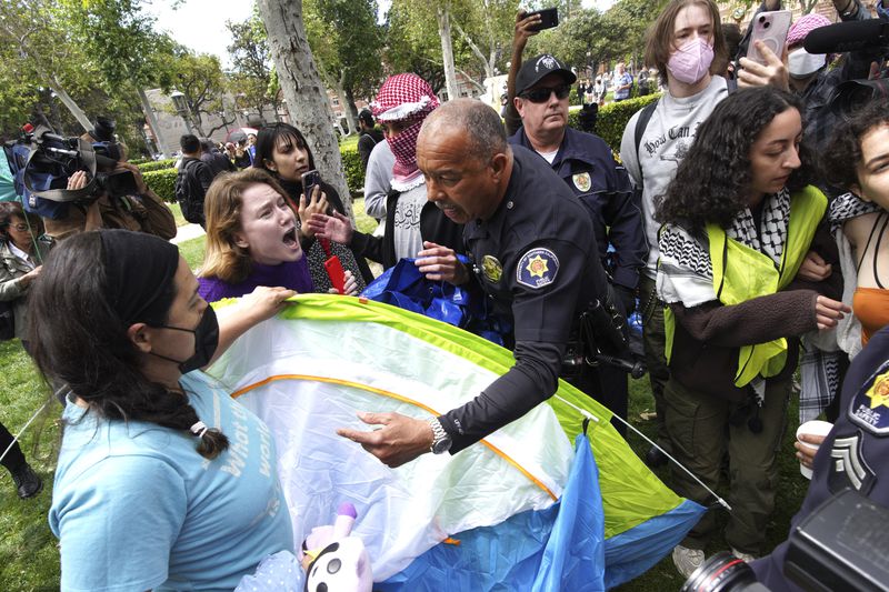 University of Southern California protesters fight with University Public Safety officers as they try to remove tents at the campus' Alumni Park during a pro-Palestinians occupation on Wednesday, April 24, 2024 in Los Angeles. (AP Photo/Richard Vogel)