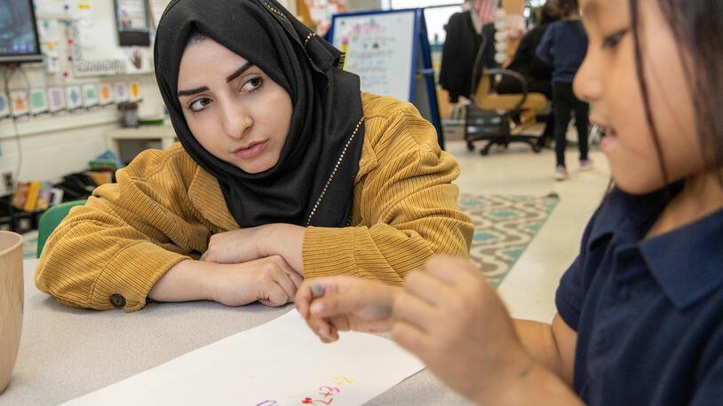 Shaikila Amiaq (left), a recent Afghan refugee who is studying to become a teacher, helps Ritu Gurung in Taylor Thomas' kindergarten class at the International Community School in Clarkston. PHIL SKINNER FOR THE ATLANTA JOURNAL-CONSTITUTION