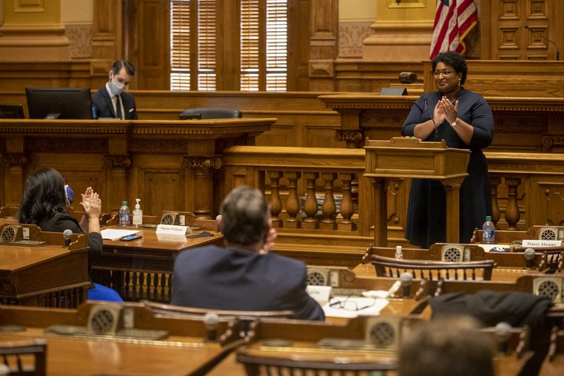 Georgia Democrat Stacey Abrams joins in applause after she and other members of Georgia's Electoral College cast their ballots in the Georgia Senate Chambers at the Georgia State Capitol building in Atlanta, Monday, December 14, 2020.  (Alyssa Pointer / AJC file photo)