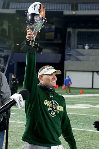 Dec. 30, 2020 - Atlanta, Ga: Grayson coach Adam Carter celebrates with the trophy after their 38-14 win against Collins Hill during the Class 7A state high school football final at Center Parc Stadium Wednesday, December 30, 2020 in Atlanta. JASON GETZ FOR THE ATLANTA JOURNAL-CONSTITUTION