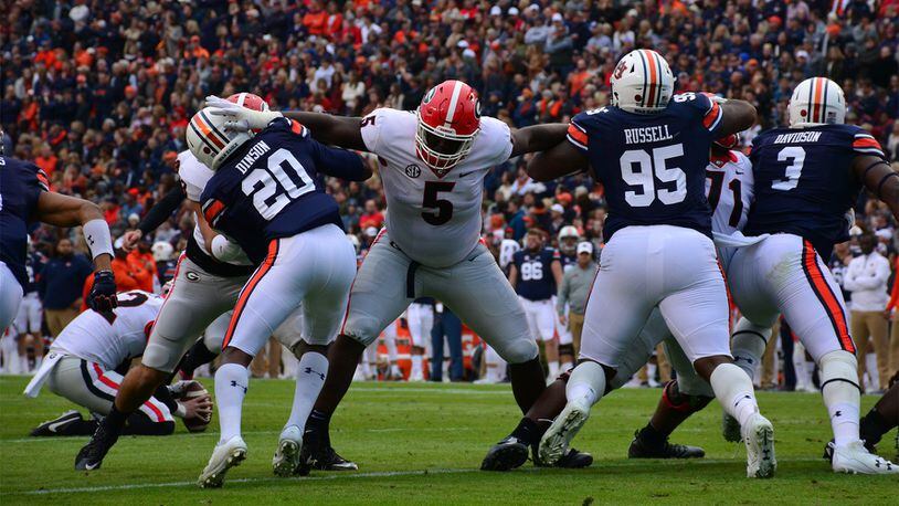 Georgia defensive lineman Julian Rochester (5) holds off two Auburn players Saturday, Nov. 11, 2017, at Jordan-Hare Stadium in Auburn, Ala. Rochester is expected to return to Georgia for a sixth season in 2021. (Caitlyn Tam/UGA)