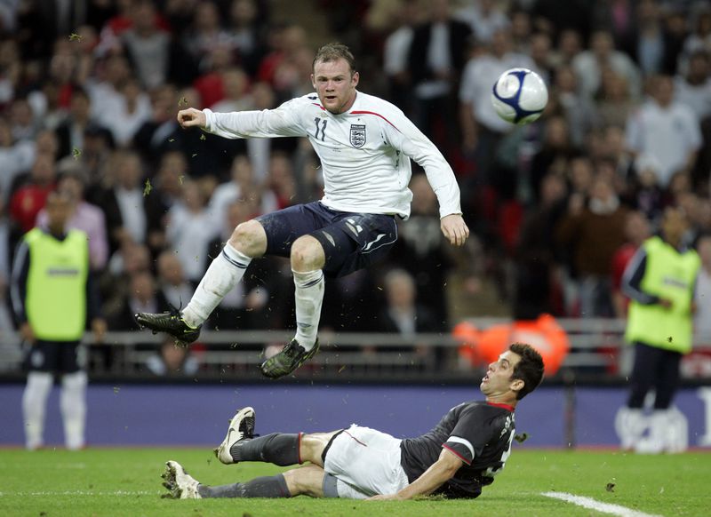 England's Wayne Rooney, top, battles for the ball with Carlos Bocanegra of the U.S. during their international friendly soccer match at Wembley stadium in London, Wednesday May 28, 2008.  England won the match 2-0.  (AP Photo/Alastair Grant)