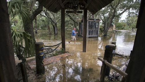 A Crab Shack restaurant employee walks through the business near Tybee Island, Ga., after winds and storm surge from Hurricane Matthew hit the small community along the east coast of Georgia, Saturday, Oct. 8, 2016. (AP Photo/Stephen B. Morton)