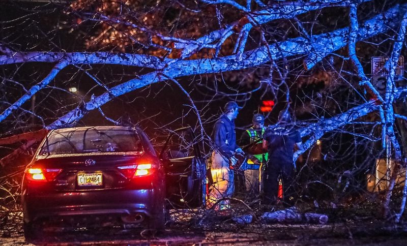 Crews work to clear a fallen tree that came down on a vehicle Monday on Crestline Drive in DeKalb County.