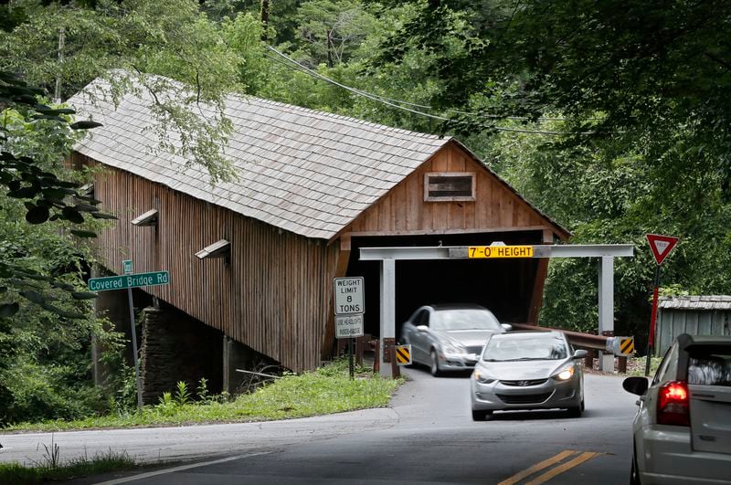 The existing metal beams (seen here) on either end of the Concord Road covered bridge will remain in place. They will be joined by a new device that involves plastic pipes suspended over the road at the same height as the bridge.  Bob Andres / bandres@ajc.com
