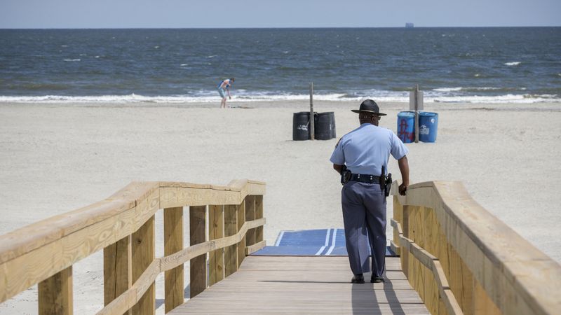 Georgia State Patrol Capt. Thornell King watches visitors to Tybee Island beach on Saturday, April 4, 2020. (Photo: Stephen B. Morton/Special to the AJC)