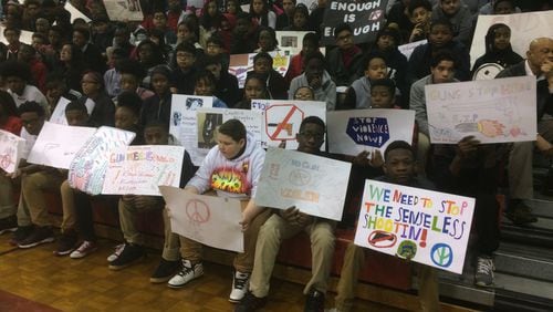 Students at Mundy’s Mill Middle School in Clayton County, some with anti-gun posters, gathered in the gym for a ceremony honoring slain Florida students and demanding action.