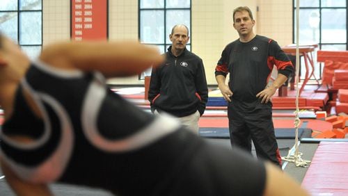 Longtime UGA gymnastics assistant coach Jay Clark, right, shown in this Jan. 5, 2010 photo in Athens, took over as head coach after serving 17 years under legendary coach Suzanne Yoculan. Assistant coach Doug McAvinn, left, is with Clark watching a UGA workout. (Brant Sanderlin/AJC file photo)