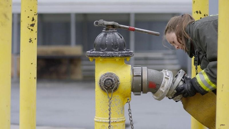 Cherokee County firefighter Grace Robertson attaches a 5-inch supply line to a fire hydrant. CONTRIBUTED BY ANNA MACKENZIE