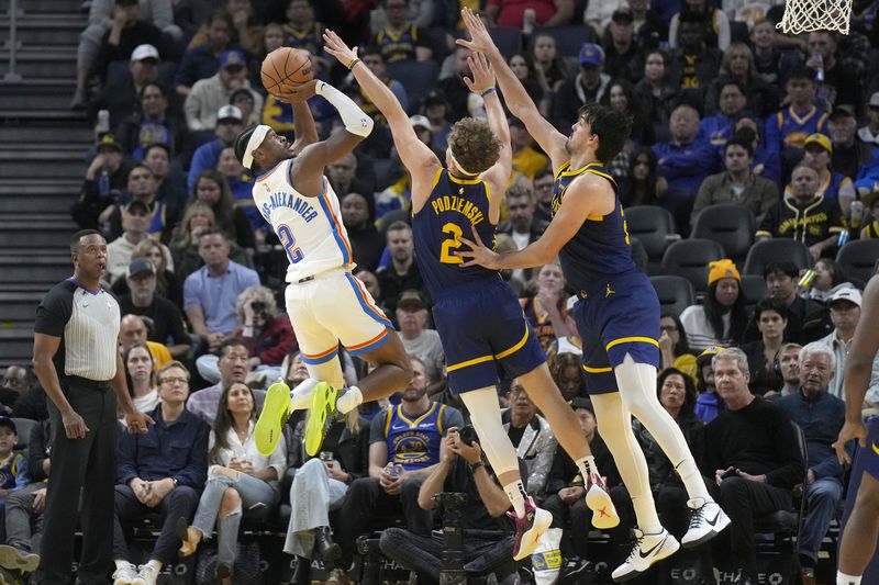 FILE - Oklahoma City Thunder guard Shai Gilgeous-Alexander, left, scores against Golden State Warriors guard Brandin Podziemski, middle, and forward Dario Saric during the second half of an NBA basketball game in San Francisco, Saturday, Nov. 18, 2023. Gilgeous-Alexander, Nikola Jokic and Luka Doncic are the three finalists for the NBA MVP Award that will be announced Wednesday, May 8, 2024. (AP Photo/Jeff Chiu, File)