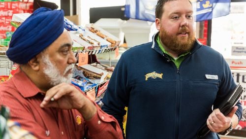 Convenience store account manager for United Distributors Scott Pitts (left) and Shell convenience store owner Raj Pal discuss the new alcohol license fees, Monday, Feb. 6, 2017. (Cory Hancock for The AJC)