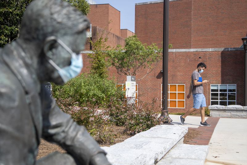  An individual wearing a face mask walks past a masked statue on the Georgia Institute of Technology campus in Atlanta, Monday, September 13, 2021. Faculty members and students from about 20 public colleges and universities in Georgia started a weeklong series of demonstrations demanding tougher COVID-19 safety measures, such as a mask mandate, in all campus buildings.
(Alyssa Pointer/Atlanta Journal Constitution)