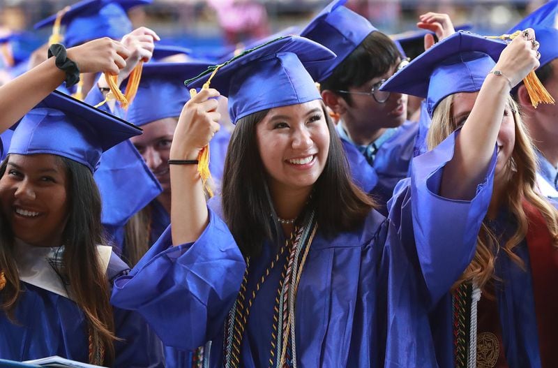 Emily Guo (center) switches her tassel during her graduation ceremony for Chattahoochee High School on May 21, 2019, at Ameris Bank Amphitheatre in Alpharetta. Guo is heading to Stanford to study the intersection of science, technology and society and hopes to help build a more environmentally “sustainable” economy. CURTIS COMPTON / CCOMPTON@AJC.COM