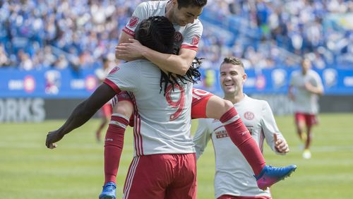 Atlanta United’s Kenwyne Jones (9) celebrates with teammates Miguel Almiron (10) and Greg Garza (4) after scoring during the first half of an MLS soccer game against the Montreal Impact, in Montreal, Saturday, April 15, 2017. (Graham Hughes/The Canadian Press via AP)