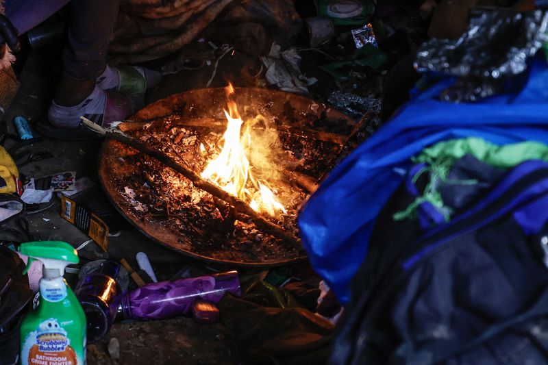 Views of a fire burning under a tent at a  homeless encampment near Cheshire Bridge Road in Atlanta shown on Friday, December 29, 2023. (Natrice Miller/ Natrice.miller@ajc.com)