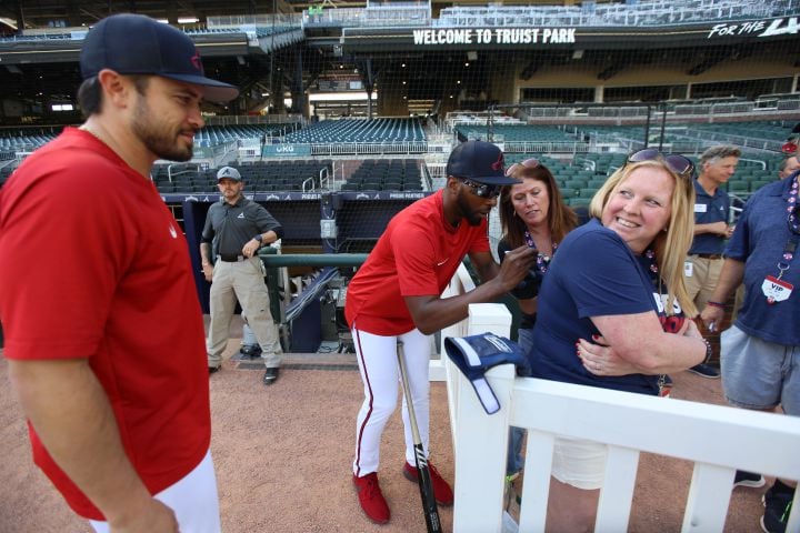Amie Marie Tolliver, who's celebrating her 40th birthday, gets an autograph by Braves outfielder Travis Demeritte (48) as she talks with Braves catcher Travis d'Arnaud at Truist Park on Wednesday April 27, 2022. Miguel Martinez/miguel.martinezjimenez@ajc.com
