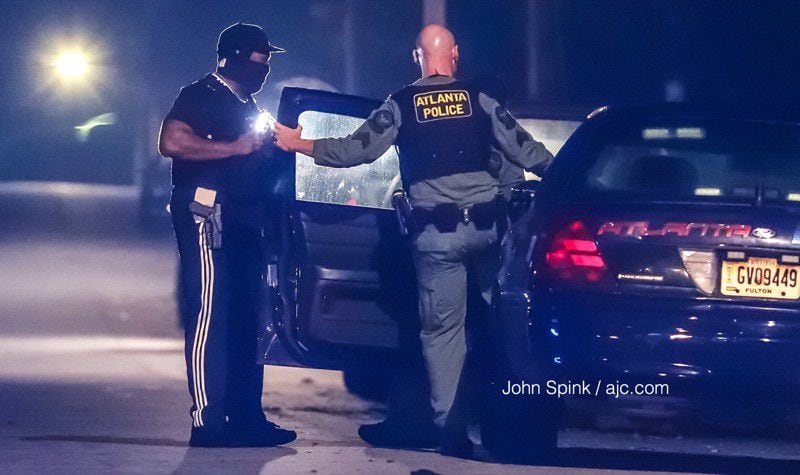 Atlanta police officers work the scene of an overnight shooting  in southwest Atlanta. About 9:30 p.m. Monday, two officers were investigating a complaint of drug activity in the 1100 block of Osborne Street when shots were fired at the patrol car, according to Channel 2 Action News. JOHN SPINK / JSPINK@AJC.COM