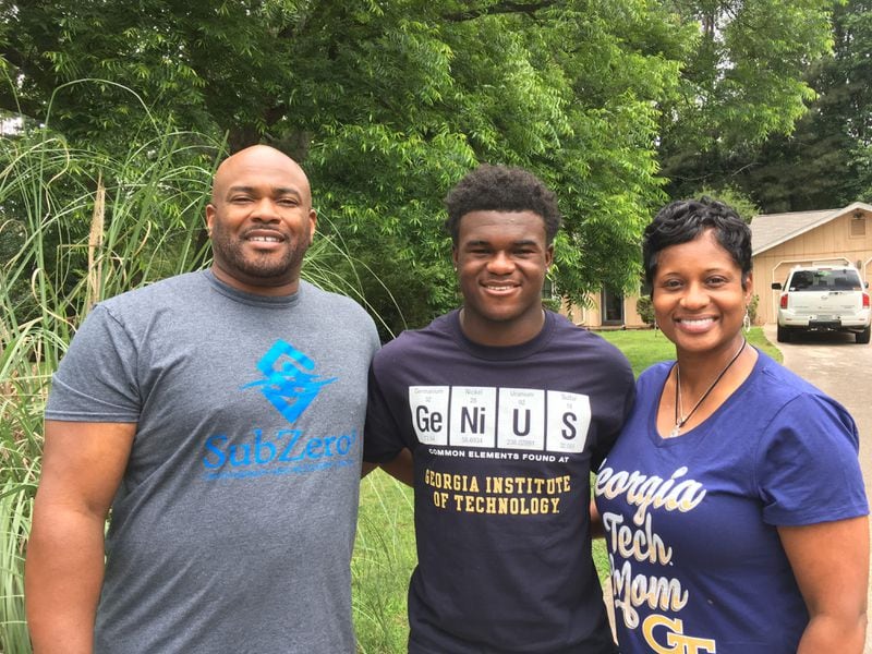 Georgia Tech freshman B-back Christian Malloy outside his family's home in Lilburn with his father,l Leonard, and mother, Traci.