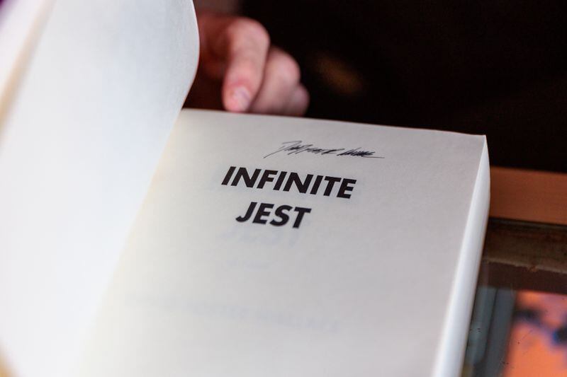 Frank Reiss, owner of A Capella Books in Atlanta, displays a signed copy of David Foster Wallace’s Infinite Jest on Friday, Aug. 5, 2022. (Arvin Temkar / arvin.temkar@ajc.com)