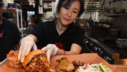 Jiyeon Lee puts the final touches on a sampler platter from Heirloom Market BBQ. (CHRIS HUNT FOR THE ATLANTA JOURNAL-CONSTITUTION)