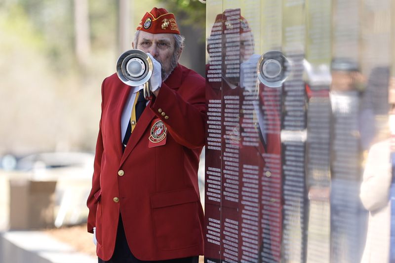 Herbet Crowe, a member of the Marine Corps League, performs taps during the dedication of the newly renovated Vietnam Veterans Memorial wall at the National Infantry Museum in Columbus on Friday, March 29, 2024. (Natrice Miller/ Natrice.miller@ajc.com)