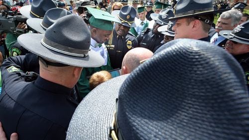 Hezekiah Jordan (center), son of fallen Griffin police officer Kevin Jordan, is surrounded by fellow officers during the Griffin High School 2014 Graduation Ceremony at Memorial Stadium in Griffin on Saturday, June 7, 2014.