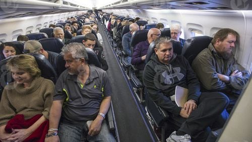 Passengers on a flight in Las Vegas, April 18, 2016. As planes fly at record capacity and new cabin configurations squeeze in ever more passengers, airlines are, intentionally or not, nudging fliers into paying extra to avoid drawing the proverbial short straw of the middle seat. (Joe Giron/The New York Times)