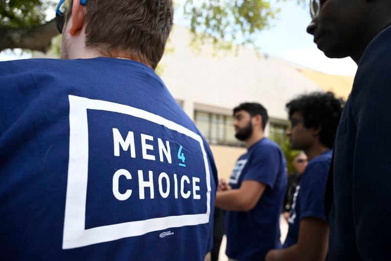Supporters wear shirts with the message "Men 4 Choice" while waiting in line to see President Joe Biden speak during a reproductive freedom campaign event at Hillsborough Community College, Tuesday, April 23, 2024, in Tampa, Fla. (AP Photo/Phelan M. Ebenhack)
