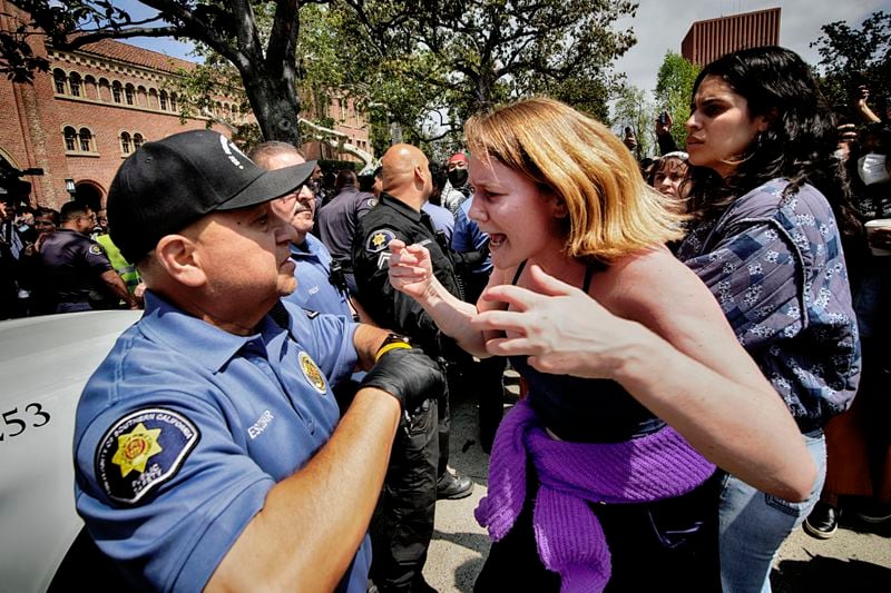 A University of Southern California protester, right, confronts a University Public Safety officer at the campus' Alumni Park during a pro-Palestinian occupation on Wednesday, April 24, 2024, in Los Angeles. (AP Photo/Richard Vogel)