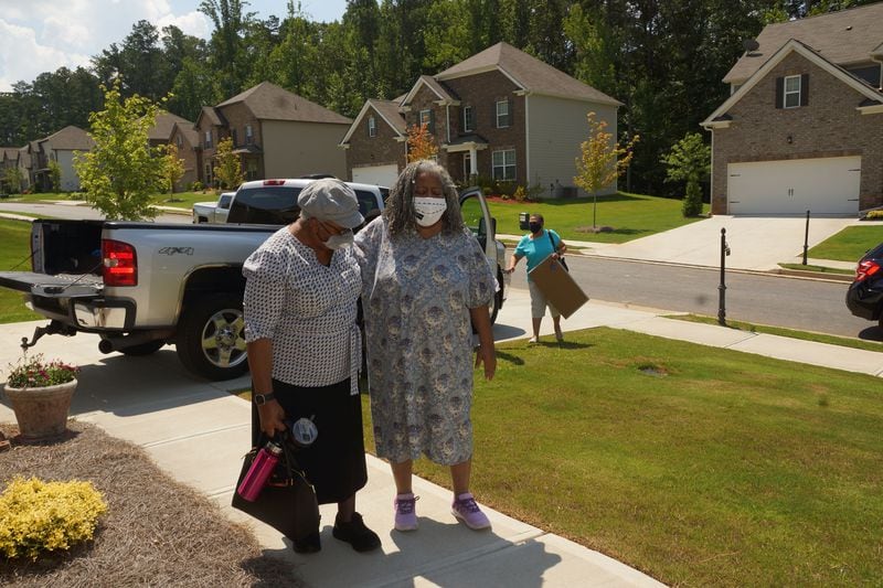 Janice Cockfield (right), steadied by her sister Drucilla Burgess, arrives at her South Fulton home on July 17, 2020, for the first time since being hospitalized for 110 days because of COVID-19. (Credit: Janese Cockfield / Contributed)