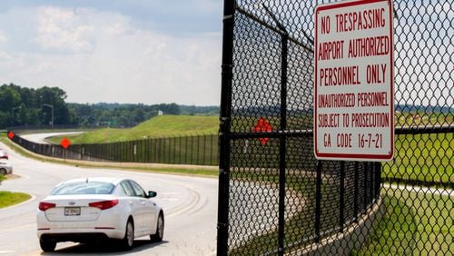 Cars drive by some of the 29.5 miles of fence that surround the Hartsfield-Jackson Atlanta International Airport July 10, 2018. STEVE SCHAEFER / SPECIAL TO THE AJC
