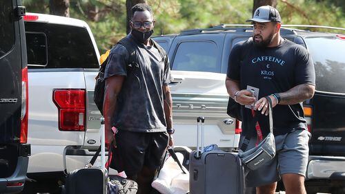 Falcons linebackers George Obinna (left) and Olive Sagapolu (right) arrive for player check in at training camp Tuesday at the team's practice facility in Flowery Branch.