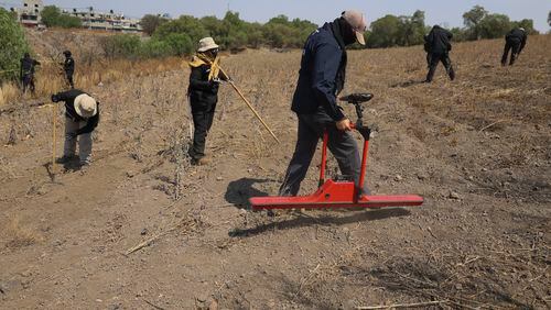 A member of the National Search Commission uses a ground-penetrating radar in an area where volunteers said they have found a clandestine crematorium in Tlahuac, on the edge of Mexico City, Wednesday, May 1, 2024. Ceci Flores, a leader of one of the groups of so-called "searching mothers" from northern Mexico, announced late Tuesday that her team had found bones around clandestine burial pits and ID cards, and prosecutors said they were investigating to determine the nature of the remains found. (AP Photo/Ginnette Riquelme)