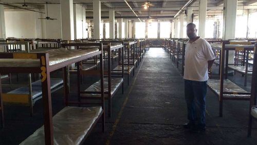 Volunteer Troy Harris in the large bedroom at Peachtree-Pine where nearly 400 men sleep. Photo by Bill Torpy