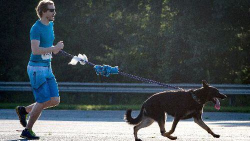 Andrew Knrdeiski and his dog Minna run during the Fast and Furry 5K fun run at Cobb County Animal Control in Marietta, GA Saturday morning June 30, 2018.