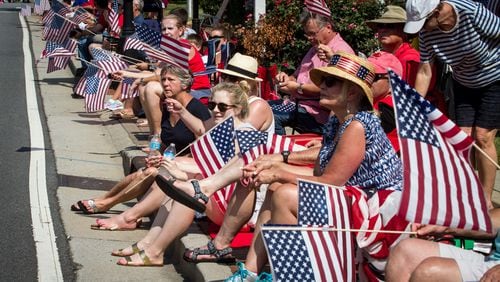 Spectators wave their flags as the Marietta Freedom Parade makes its way down Roswell Street on Tuesday, July 4, 2016, In Marietta, GA. An estimated 30,000 spectators turned out for the parade. STEVE SCHAEFER / SPECIAL TO THE AJC