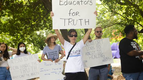 Sally Stanhope, a social studies teacher at Chamblee High School, holds up a homemade sign during a back-to-school rally for Georgia educators on Saturday, July 23, 2022, at Piedmont Park in Atlanta. Teachers, community members and students gathered to speak against new state legislative action banning selected books from school libraries and prohibiting the teaching of divisive concepts in U.S. History.  (Christina Matacotta for The Atlanta Journal-Constitution)