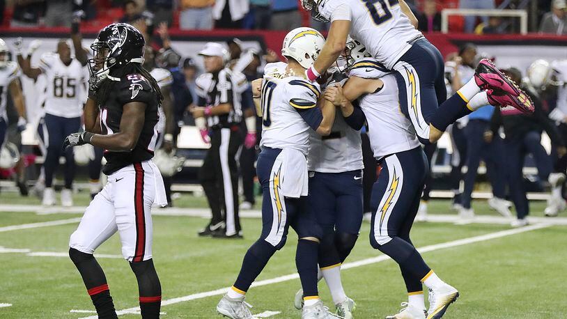 Atlanta Falcons cornerback Desmond Trufant, left, walks off the field as the San Diego Chargers mob kicker Josh Lambo as his sudden death field goal defeats the Falcons 33-30 in an NFL football game on Sunday, Oct. 23, 2016, in Atlanta. (Curtis Compton/Atlanta-Journal Constitution via AP)