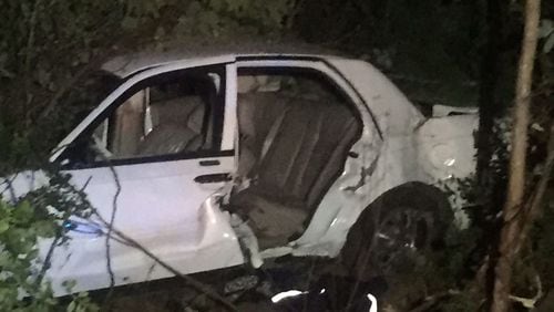 A passenger died when this car ran off a south DeKalb County road, hitting a parked car and pushing that car into the corner of a garage. (Credit: Channel 2 Action News)
