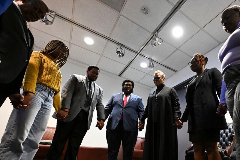 Rev. Gina Stewart, third from right, holds hands with students and faculty of Howard University before church service at Rankin Chapel, Sunday, April 7, 2024, in Washington. Throughout its long history, the Black Church in America has, for the most part, been a patriarchal institution. Now, more Black women are taking on high-profile leadership roles. But the founder of Women of Color in Ministry estimates that less than one in 10 Black Protestant congregations are led by a woman. “I would hope that we can knock down some of those barriers so that their journey would be just a little bit easier,” said Stewart. (AP Photo/Terrance Williams)
